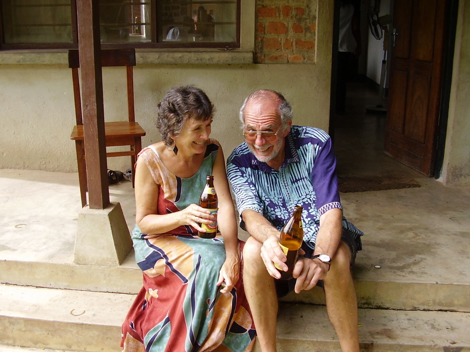 Man and woman holding a beer and laughing